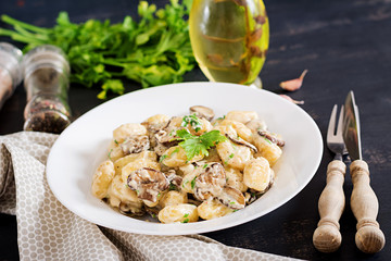 Gnocchi with a mushroom cream sauce and parsley  in bowl on a dark background