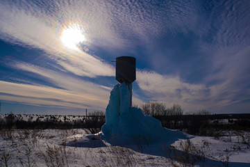 High water tower with a large block of blue ice.