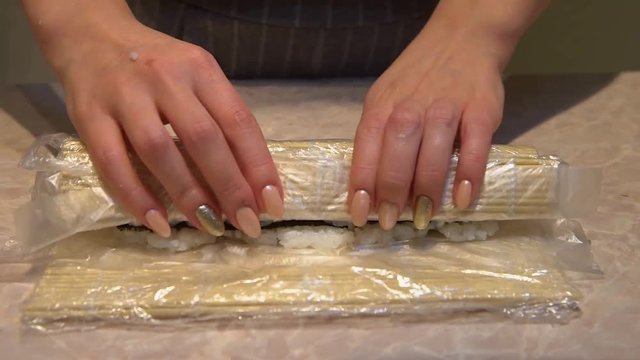 Close up of a woman preparing homemade sushi