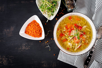 Soup with lentils, carrots, chicken meat, paprika, celery  in a bowl. Top view