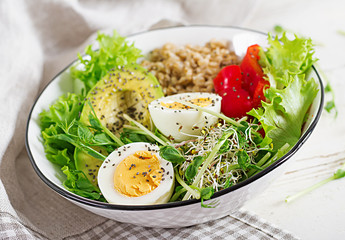 Fresh salad. Breakfast bowl with oatmeal, paprika, avocado, lettuce, microgreens and boiled egg. Healthy food. Vegetarian buddha bowl.