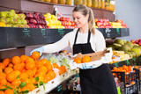 Salesgirl arranging goods in greengrocery