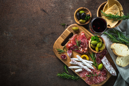 Antipasto - sliced meat, ham, salami, olives and wine  top view.
