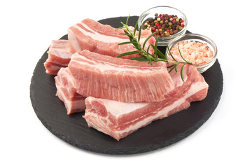 Raw fresh pork ribs with rosemary and spices, close-up, isolated on white background