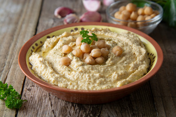 Delicious homemade hummus pasta with olive oil and chick-peas. Wooden table. Healthy food.