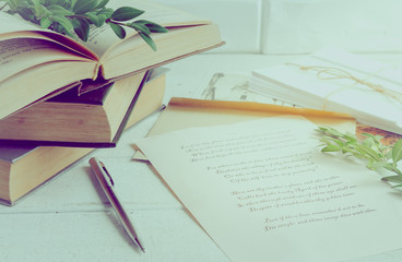 Books, pen, poems of Shakespeare on the old wooden table. The process of writing a love letter