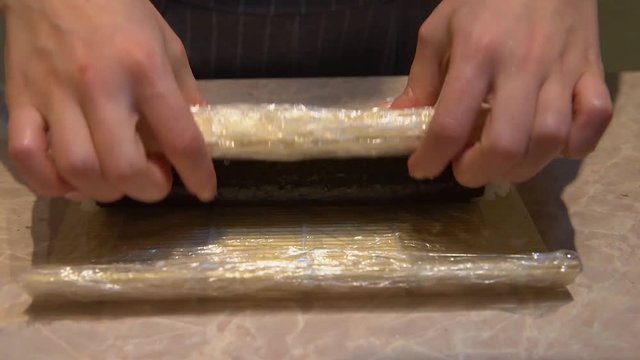 Close up of a woman preparing homemade sushi