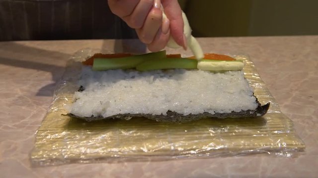 Close up of a woman preparing homemade sushi