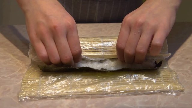 Close up of a woman preparing homemade sushi