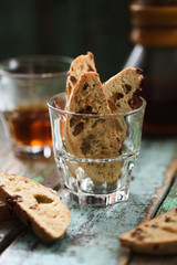 Traditional Italian pastry biscotti or cantucci in glass served with filtered coffee on old shabby wooden background