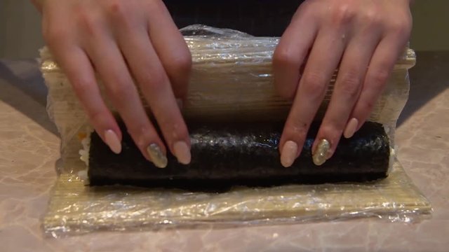 Close up of a woman preparing homemade sushi