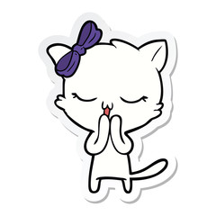 sticker of a cartoon cat with bow on head