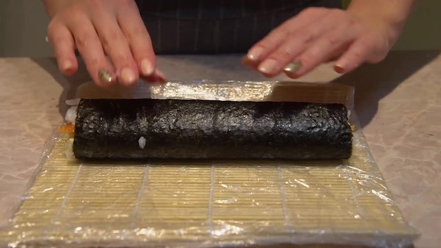 Close up of a woman preparing homemade sushi
