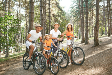 Happy family on bicycles for a walk in park.