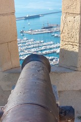 A footbridge that links one side of Alicante’s fort to the other during mid morning with the sun casting long shadows inside the moat of this ancient fort in southern Spain.