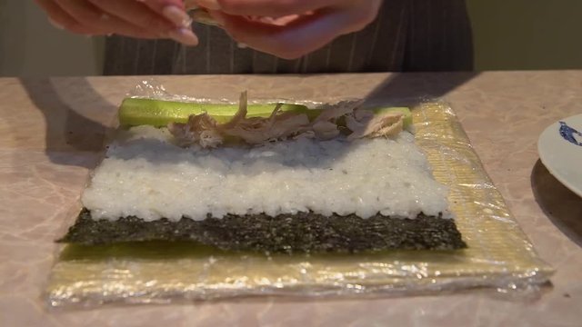 Close up of a woman preparing homemade sushi