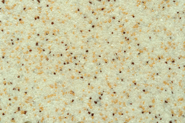 Texture of beige ceramic coating with dark inclusions.