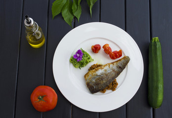 Grilled fish and vegetable on plate