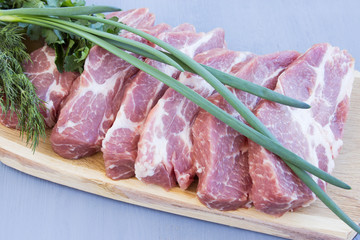 Raw pork steaks on a wooden board. Fresh pork meat prepared for grilling.