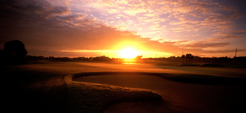 Panoramic view of golf course at sunrise.