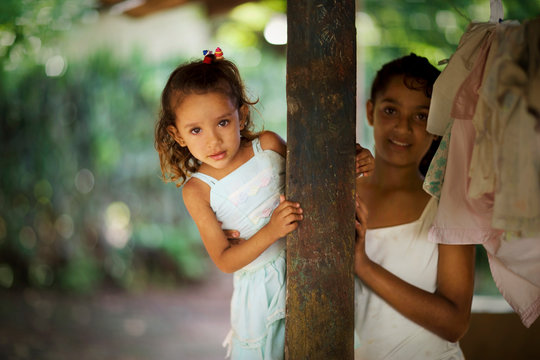 View of two girls holding a pillar.