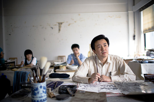 Mid-adult man sitting in an art classroom.