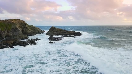 Aerial drone footage of waves crashing over rocks on California coast.