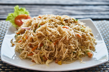 Plate with noodles on a wooden background. View from above.