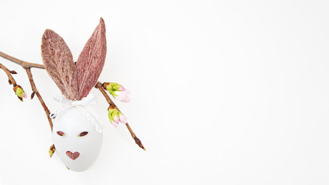 Ester egg with bunny ears, cherry branch