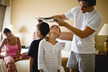 Father comparing the heights of his two children.