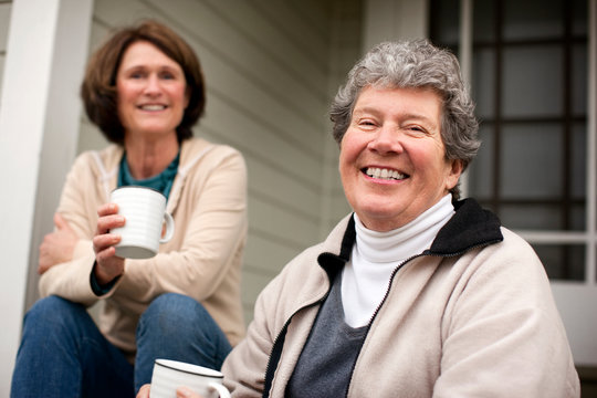A mother and daughter catching up over coffee on the front stoop.