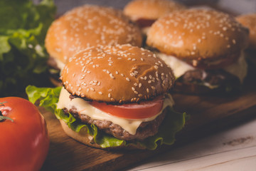 Нamburger or sandwich on brown paper. Delicious sandwich hamburger with meat, cheese and fresh vegetable. Hamburger or sandwich is the popular fast food for brunch or lunch. Juicy cheeseburger