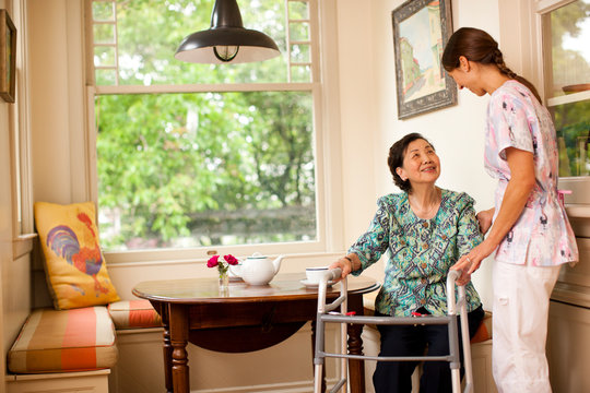 Senior woman receiving a visit at home from her nurse.