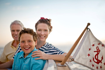 Family portrait of smiling young boy and his parents on a boat.