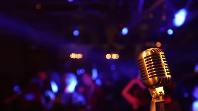 Retro microphone close up against blur colorful light in pub and restaurant background