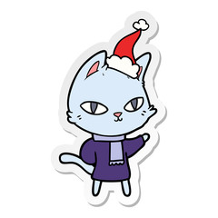 sticker cartoon of a cat staring wearing santa hat