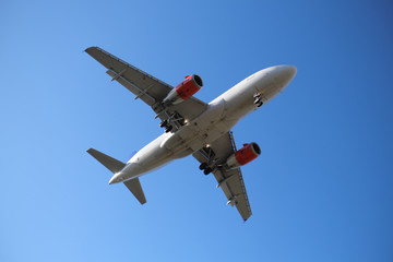 Fototapeta na wymiar Zweistrahliges Flugzeug in der Luft mit roten Triebwerken - Stockfoto