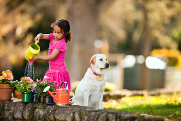 Young girl watering plants in the garden.