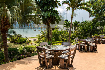 Dining tables made of wood and glass on the shores of the South China Sea on Koh Chang island, Thailand