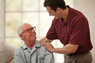 Happy elderly man having a discussion with a male nurse.