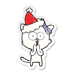distressed sticker cartoon of a cat wearing santa hat
