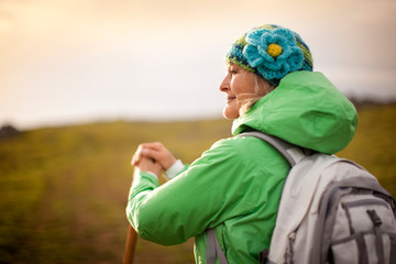 Confident mature woman hiking in the countryside.
