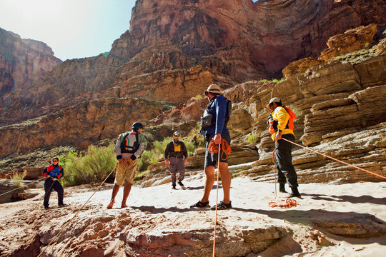 Group of friends rock climbing in a canyon park.