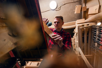 Obraz na płótnie Canvas Professional carpenter using drill in workshop
