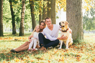Fototapeta premium Happy family with their dog in the park on a sunny day