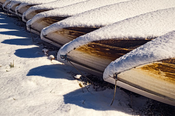 boats on the bank with snow on them