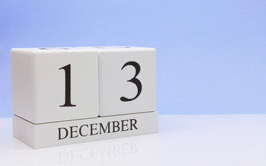 December 13st. Day 13 of month, daily calendar on white table with reflection, with light blue background. Winter time, empty space for text