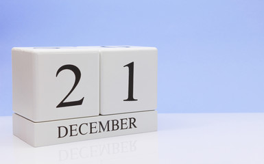 December 21st. Day 21 of month, daily calendar on white table with reflection, with light blue background. Winter time, empty space for text