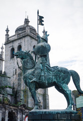 Obraz premium Statue of Vimara Peres with tower of Porto Cathedral on the background.