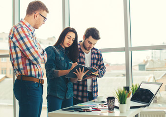 Group of international university students having fun studying in library, three colleagues of...